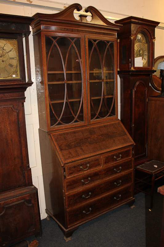 An Edwardian inlaid mahogany George III style bureau bookcase with swan neck arch cornice, oval