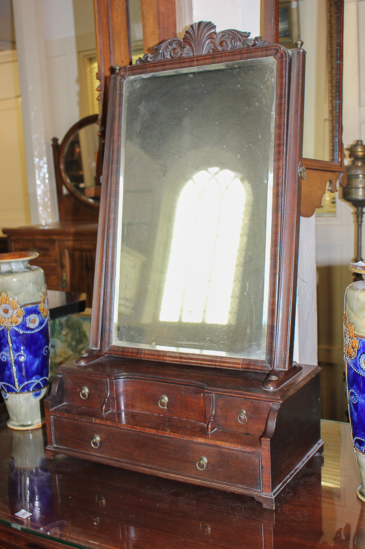 A rectangular mahogany dressing table mirror with carved shell and foliate surmount, on box base