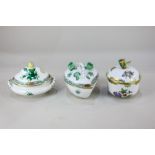 Three Herend porcelain pots and covers, one circular with butterfly finial, another oval in the