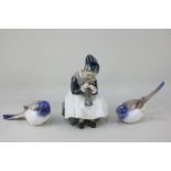 A Royal Copenhagen porcelain figure of a seated girl sewing, together with a pair of Bing and
