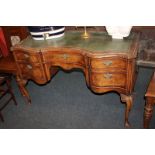 A Queen Anne style walnut desk, serpentine shaped front, with five drawers, on cabriole legs, 123cm