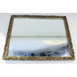 A gilt framed rectangular wall mirror with scrolling foliate decoration, mirror plate 43.5cm by 33.