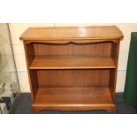 An Ercol Golden Dawn bookcase with single shelf, on shaped bracket base, 92cm