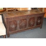 A carved oak coffer with four-panel front and frieze decorated with rose and fleurs-de-lis diamond