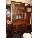 An early 19th century mahogany bureau bookcase with two glazed panel doors enclosing three