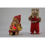 Two 20th century mechanical toys, a bear with a baby book and a doll with maracas