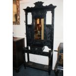 A Flemish style stained oak hall stand with mirror panel back, hat and coat hooks, with glove box