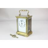 A brass carriage clock with white enamel dial and Roman numerals, 14cm high