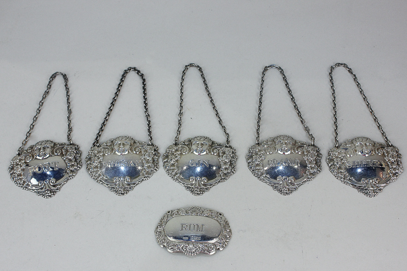 A set of five Elizabeth II embossed silver decanter labels of bacchanalian design, maker Turner &