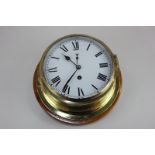 A brass bulkhead wall clock with Roman numerals, on wooden mount, 21.5cm diameter, (LC)