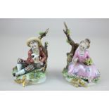 A pair of Capodimonte porcelain figures of a girl with flowers and boy with dove, each seated by a