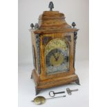 A gilt metal mounted oak mantel clock with arched brass dial, with silvered chapter ring, movement