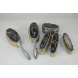 A set of four silver mounted and tortoiseshell dressing table brushes, a matched oval box, maker W &