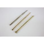 A 9ct gold propelling pencil with twist mechanism,. a silver propelling pencil and a gilt metal
