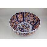 A large Japanese Imari porcelain bowl with scalloped rim, decorated with central circular panel