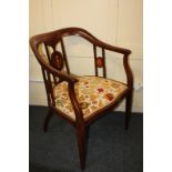 An Edwardian inlaid mahogany occasional chair with continuous arms and oval pierced back splats