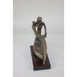 A bronze figure of a woman embracing a child, stylised flowing form, mounted on rectangular wooden