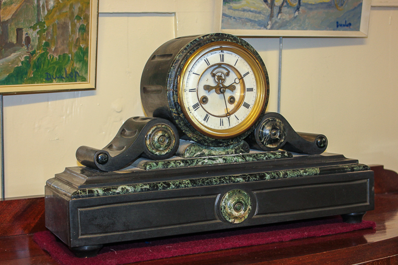 A Victorian slate mantel clock with white enamel and brass dial, in drum shape case with scroll