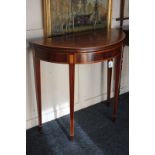 A Sheraton style mahogany semi-lune card table with banded lifting top, on square tapered legs