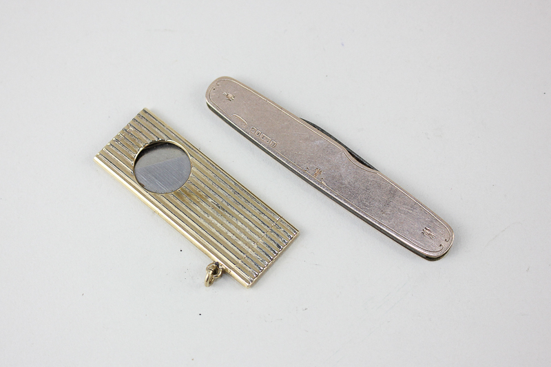 A 9ct gold cigar cutter by R. Weiss and a 9ct gold penknife