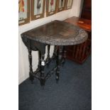 A stained oak gate-leg table, oval top with carved border, on turned supports, opens to 84cm, (LC)