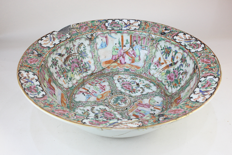 A Chinese Cantonese large porcelain bowl decorated with panels of figures and blossom in famille