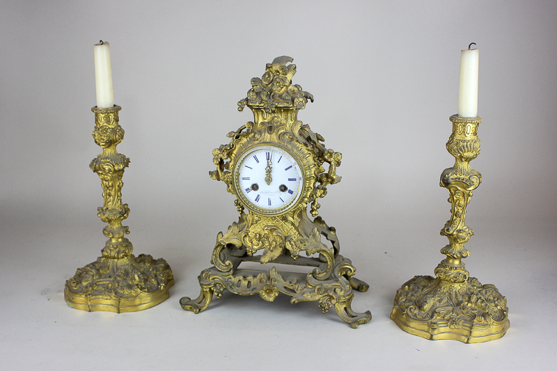 A 19th century French clock garniture, the white and blue enamel dial marked Hodgkins & Co, À Paris,