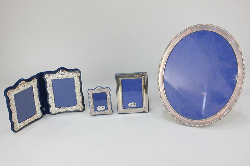 A silver plated oval photograph frame, together with four other silver plated frames