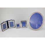 A silver plated oval photograph frame, together with four other silver plated frames