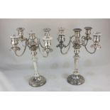 A pair of large silver plated four-branch candelabra with five sconces with embossed scroll borders,