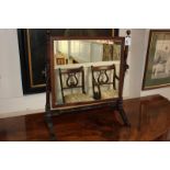 A rectangular mahogany framed dressing table mirror on turned supports with brass adjusting knobs,