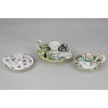 Three 19th century porcelain chamber sticks, one with bocage floral design, the other two with