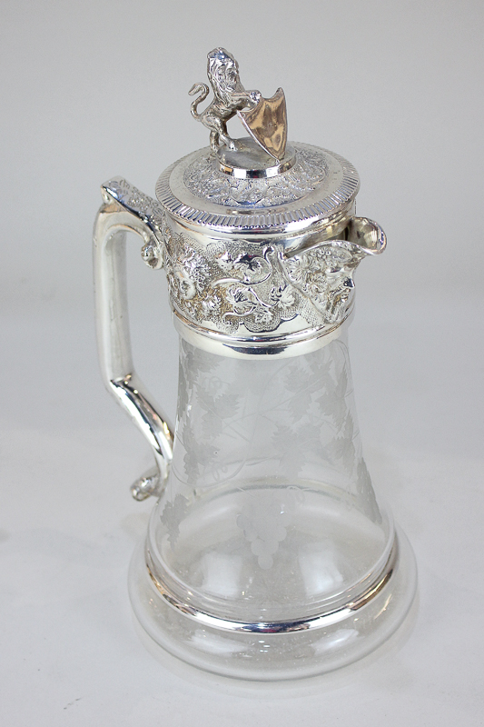 A silver plate mounted cut glass wine jug, the glass etched with vines and bunches of grapes, the