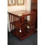 An Edwardian inlaid mahogany revolving book stand, square top with central motif, slatted sides,