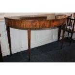 A Sheraton style mahogany demi-lune side table with banded top, on tapered legs and spade feet,