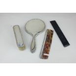 A George V silver mounted three-piece dressing table set of hand mirror, comb and clothes brush,