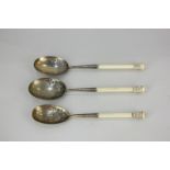 A pair of Victorian silver gilt serving spoons with chased floral design and carved ivory handles,