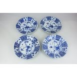 Four Chinese blue and white porcelain plates, each with central panel of birds and plants within a