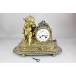 A French brass gilt metal mantel clock, drum shaped dial (lacks glass) flanked by seated Cupid, oval