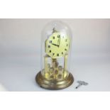 An anniversary gilt metal mantel clock with hexagonal shaped dial, signed Keen, under glass dome, on