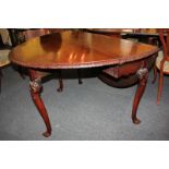 An 18th/19th century mahogany oval drop-leaf table with carved decorative border, on scroll and