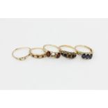 A sapphire three-stone ring in 14ct gold, three other gem set rings, and a gold 'Fede' ring (