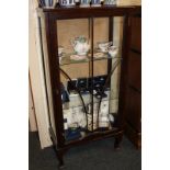 A mahogany display cabinet with two glass shelves enclosed by panel glazed door on cabriole legs,