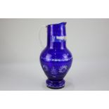 A Bohemian blue glass jug with clear cut decoration, 30cm high