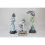 A pair of Lladro porcelain geisha figures, one holding a parasol, the other bowing, tallest 29cm