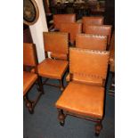 A set of eight Cromwellian style oak dining chairs with brass studded leather backs and seats,