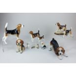 A collection of eleven various porcelain models of beagles, including two Beswick porcelain models