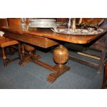An oak draw-leaf table, with two pull out ends, on large carved bulbous supports with uniting