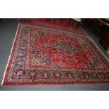 A Turkish wool rug, central scalloped design with floral design with multi-line borders, blue and