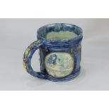 An Edward Bingham Castle Hedingham pottery tankard decorated in relief with three roundels for